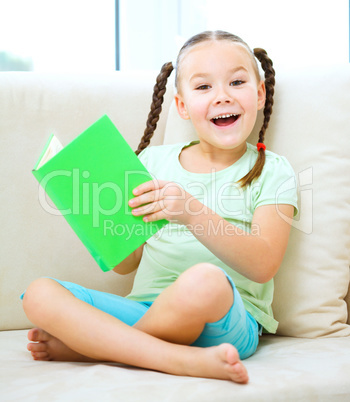 Little girl reads a book