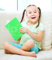 Little girl reads a book