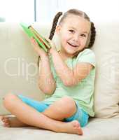 Little girl reads a book