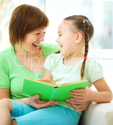 Mother is reading book with her daughter