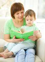 Mother is reading book for her son