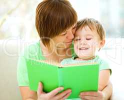 Mother is reading book for her son