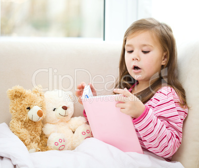 Little girl is reading a story for her teddy bears