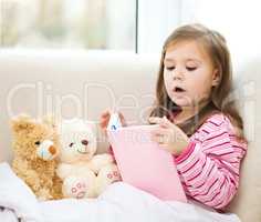 Little girl is reading a story for her teddy bears