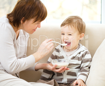 Mother is feeding her son