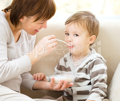 Cute little boy is fed using spoon