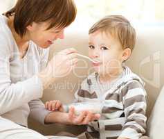 Cute little boy is fed using spoon