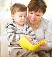 Mother is reading book for her son