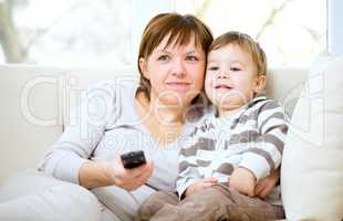 Mother and her son are watching tv