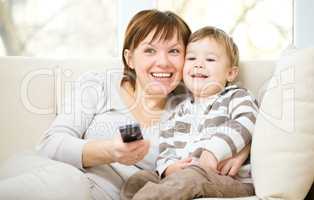 Mother and her son are watching tv