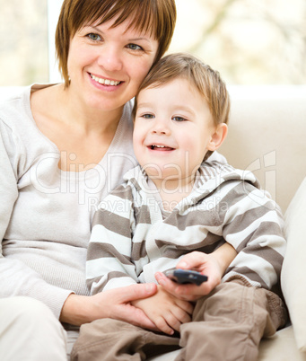 Mother and her son are watching tv