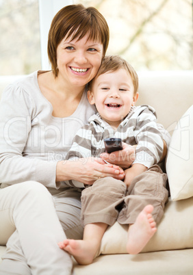 Mother and her son are watching tv show