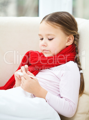 Ill little girl is reading thermometer