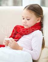 Ill little girl is reading thermometer