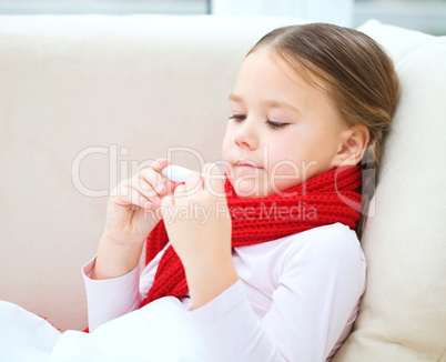 Ill little girl is reading thermometer