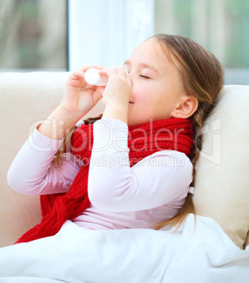 Little girl spraying her nose