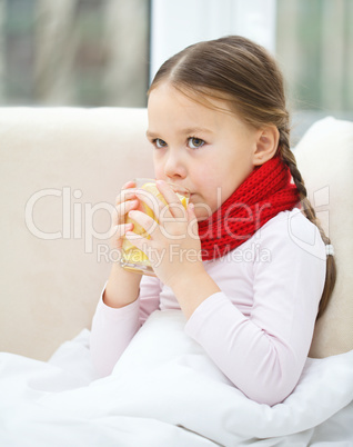 Ill little girl is drinking vitamin cocktail