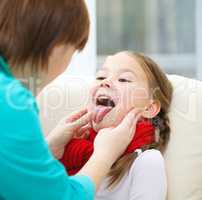 Doctor is examining little girl