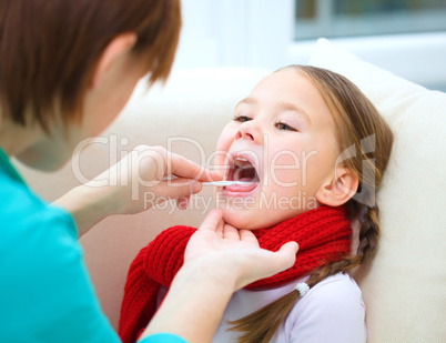 Doctor is examining little girl