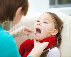 Doctor is examining little girl