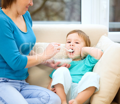 Cute little boy is fed using spoon