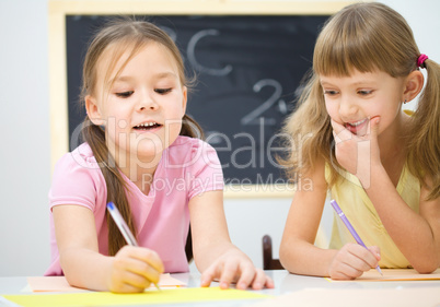 Little girls are writing using a pen