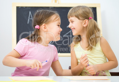 Little girls are writing using a pen