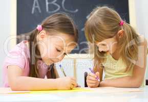 Little girls are writing using a pen