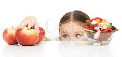 Little girl is reaching apple
