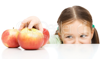Little girl is reaching apple