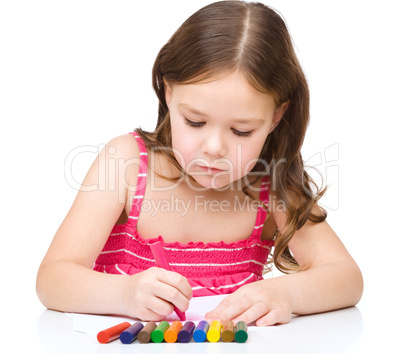 Little girl is drawing using a crayons