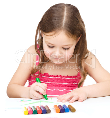 Little girl is drawing using colorful crayons