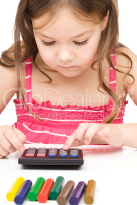 Little girl is playing with calculator