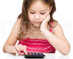 Little girl is using calculator