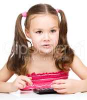 Little girl is using calculator