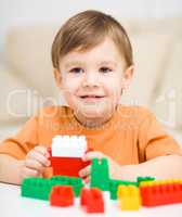 Boy is playing with building blocks