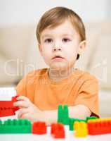 Boy is playing with building blocks