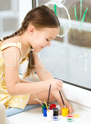 Portrait of a cute girl playing with paints