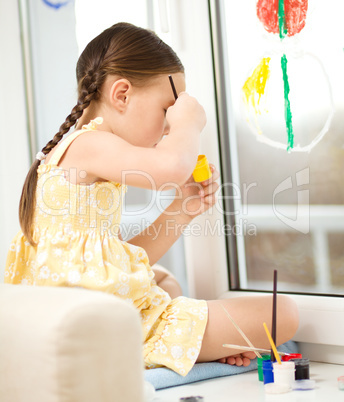 Portrait of a cute girl playing with paints