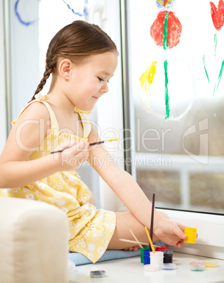 Portrait of a cute girl playing with paints