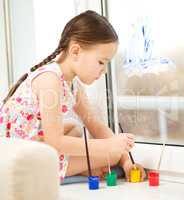 Portrait of a cute girl playing with paints