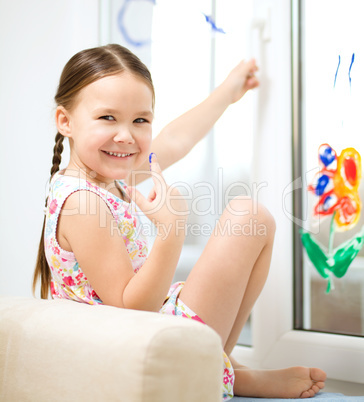 Portrait of a cute girl playing with paints