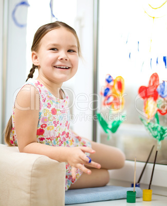 Portrait of a cute girl playing with paints