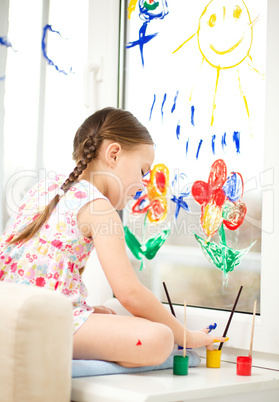 Portrait of a cute girl playing with paints