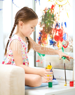 Portrait of a cute girl playing with paints