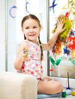 Portrait of a cute girl playing with paints