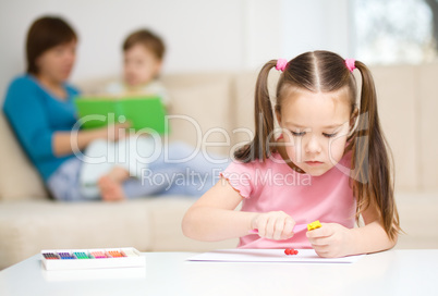 Little girl is playing with plasticine