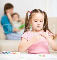 Little girl is playing with plasticine