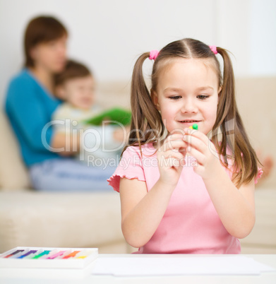 Little girl is playing with plasticine