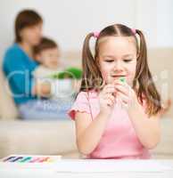 Little girl is playing with plasticine